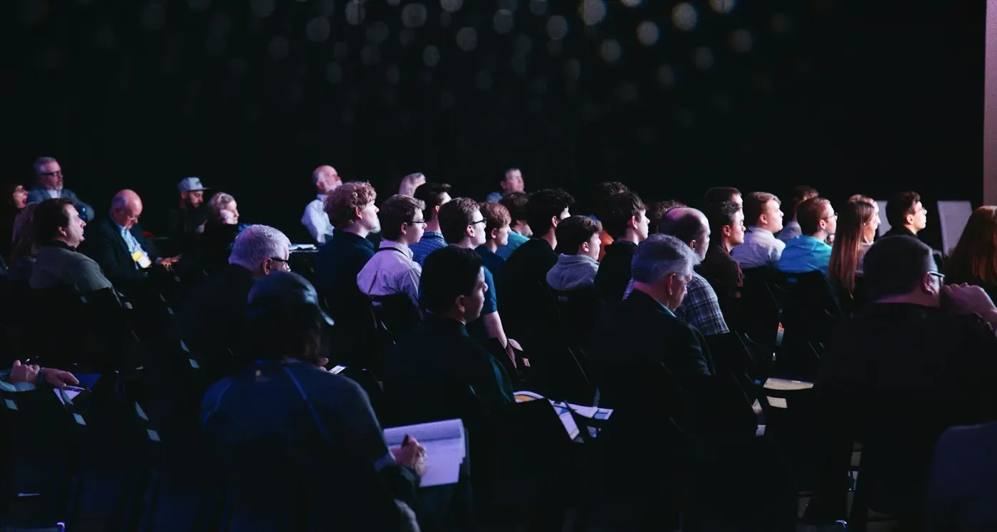 Plateia de um evento empresarial acompanhando uma apresentação no auditório